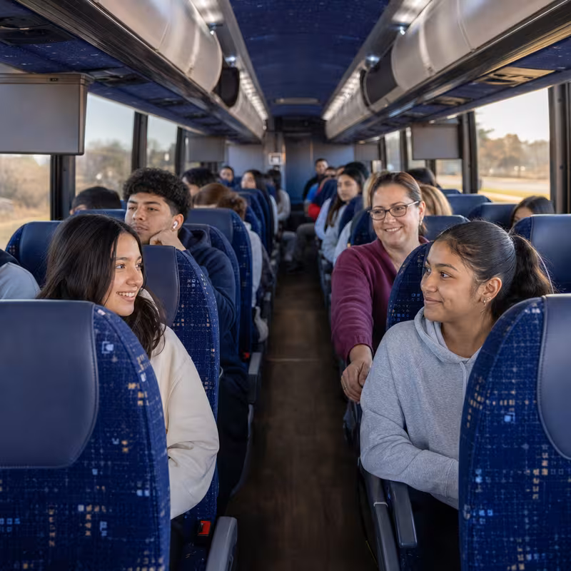 Group boarding a white charter bus for School Transportation transportation in Cleveland