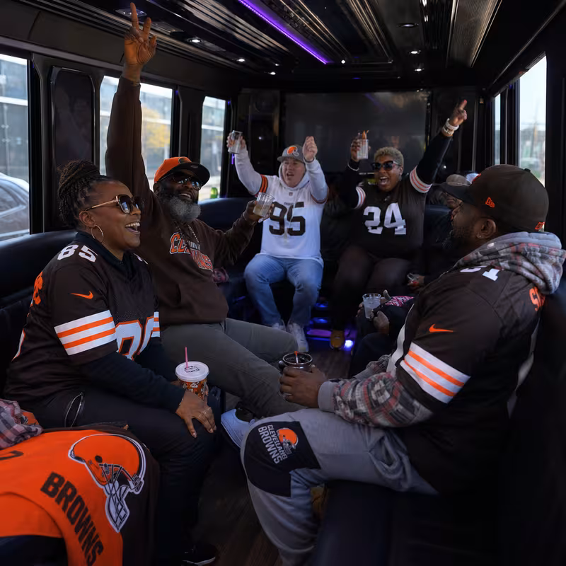 Group boarding a white charter bus for Sporting Event Transportation transportation in Cleveland